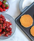 Two Burner Griddle For Gas And Electric Stoves Nonstick Aluminum 10.3 X 17.4 Inches with pancakes next to fruit