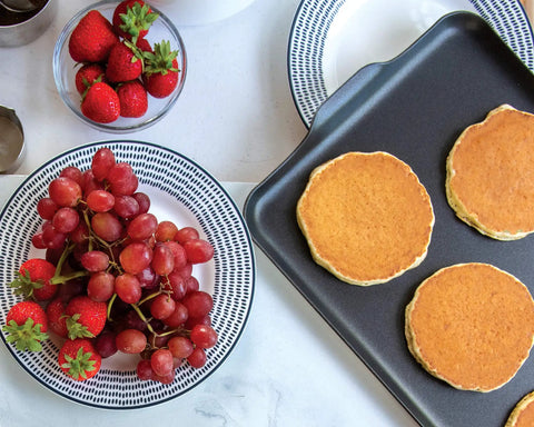 Two Burner Griddle For Gas And Electric Stoves Nonstick Aluminum 10.3 X 17.4 Inches with pancakes next to fruit