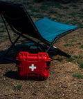 Mini Pro Waterproof First Aid Kit For Car, Home, Boat, Camping And Travel near folding chair on dirt ground