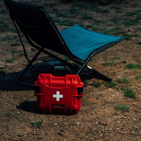Mini Pro Waterproof First Aid Kit For Car, Home, Boat, Camping And Travel near folding chair on dirt ground