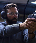 Man wearing Ultra Comfy 37 Db NRR Safety Ear Muffs For Shooting And Industry Work High Noise Reduction Earmuffs at a shooting range