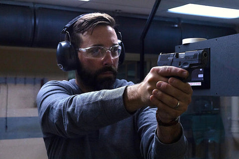 Man wearing Ultra Comfy 37 Db NRR Safety Ear Muffs For Shooting And Industry Work High Noise Reduction Earmuffs at a shooting range