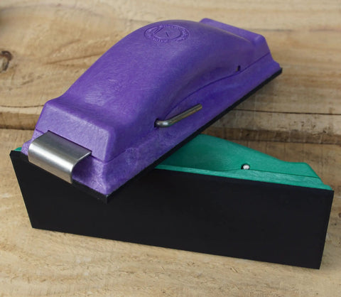 Purple and green ergonomic sanding block on wooden surface, part of the Ergonomic Sanding Block For Wet Or Dry Sanding Easy Load Plain Paper Sander Complete Five Color Code Hand Sanders Set In Yellow Blue Green Purple And Red Time Saver Tool For Quick Grinds