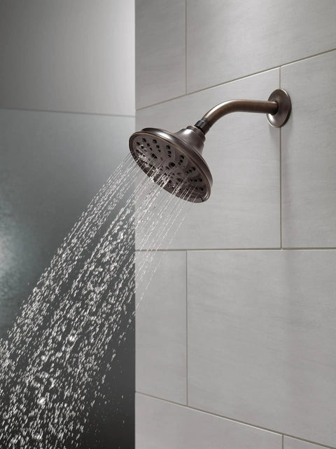 Five Setting Raincan Shower Head With H2Okinetic Spray in Venetian Bronze, showing water flow and wall-mounted installation.