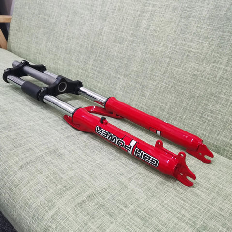Red 26 Inch Suspension Front Fork With One And One Eighth Inch Headset Disc Brake Ready Triple Tree on a green couch