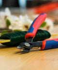 5-Inch Electronics Super Knips with Comfort Grip, Flush-Cut Snips for PCBs and Fiber Optic Cables on table with wire