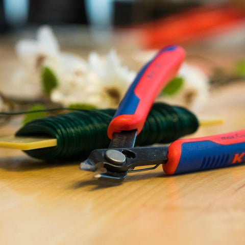 5-Inch Electronics Super Knips with Comfort Grip, Flush-Cut Snips for PCBs and Fiber Optic Cables on table with wire