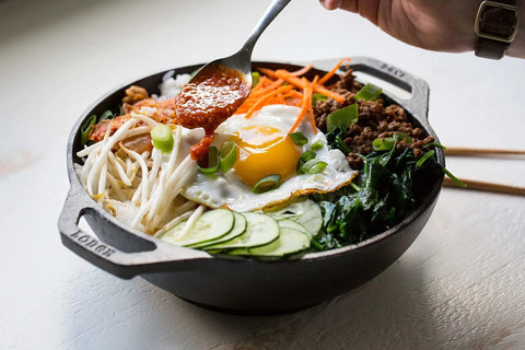 Mini Cast Iron Wok For Stir Fry Lovers with food, 9 inch naturally seasoned, features egg, vegetables, sauce being added