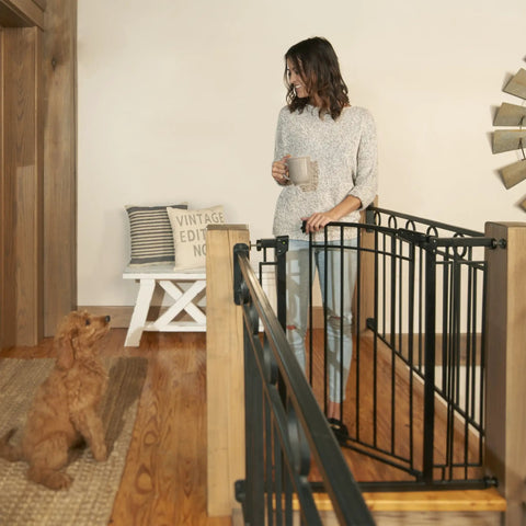 Woman with dog by Multi-Use Tall Walk-Thru Baby Gate In Black Metal, Pressure Mount Or Hardware Mount Options, Adjustable 28 To 48 Inch Wide