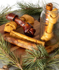 Made In USA Premium Beefhide Dog Chews Assorted Bones And Rolls For Strong Chewers Beef And Chicken Flavor displayed on board