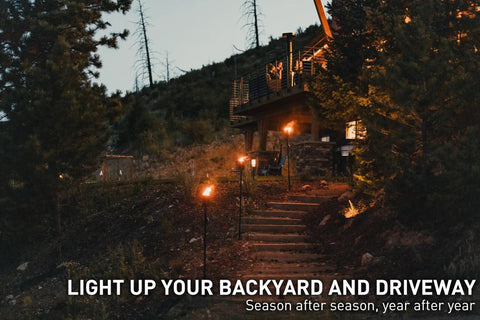 Mesa Torch 3 Pack Outdoor Backyard Torches With 5 Hour Burn Time in cold rolled steel lighting up a driveway at night