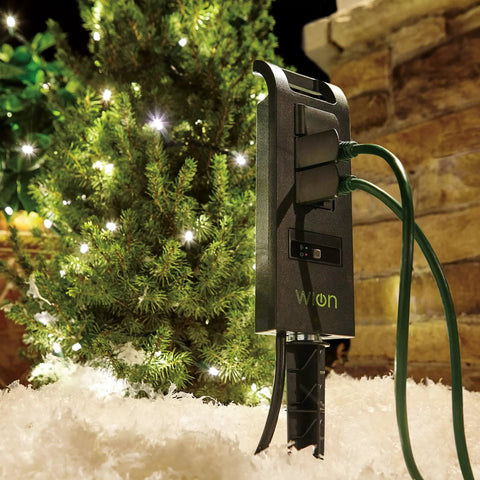 Outdoors WiFi Smart Yard Stake Plug With Three Weatherproof Outlets And Six Foot Cord Straight Up Easy Smartphone Control For Landscape Lighting And Patio Setup Totally Hub Free in snowy garden setting.