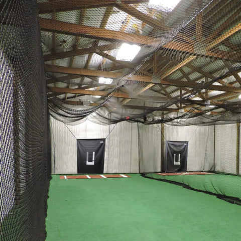 Indoor baseball and softball batting cage net with roof view, showcasing twisted knotted black polyethylene and hitters door access.
