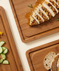 Top Shelf Wooden Cutting Boards For Kitchen Meal Prep And Serving With Deep Juice Groove And Sturdy Handles Real Deal Charcuterie Serving Tray And Tough Butcher Block For Steak Slicing And Daily Cooking Three Piece Set with sliced chicken and vegetables.