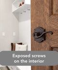 Entry Door Lever Handle With Keyed Lock And SmartKey Re-key Technology on wooden door, exposed screws shown, in Venetian Bronze.