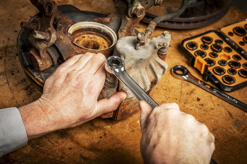 Mechanic using Bolt Biter Wrench Insert Set, 30-Piece SAE and Metric Kit for Damaged Fasteners on rusty component