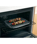 Universal Broiler Pan With Rack For Oven Nonstick Two Piece Black Porcelain Coated Carbon Steel Roasting Pan in use with kebabs
