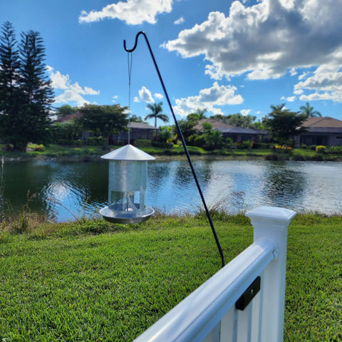 Heavy Duty 34 Inch Deck Shepherd Hook For Vertical Spindled Railings Hangs Bird Feeders And Flower Baskets Rock Solid Steel Hanger with feeder beside water.
