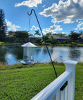 Heavy Duty 34 Inch Deck Shepherd Hook For Vertical Spindled Railings Hangs Bird Feeders And Flower Baskets Rock Solid Steel Hanger with feeder over a pond.