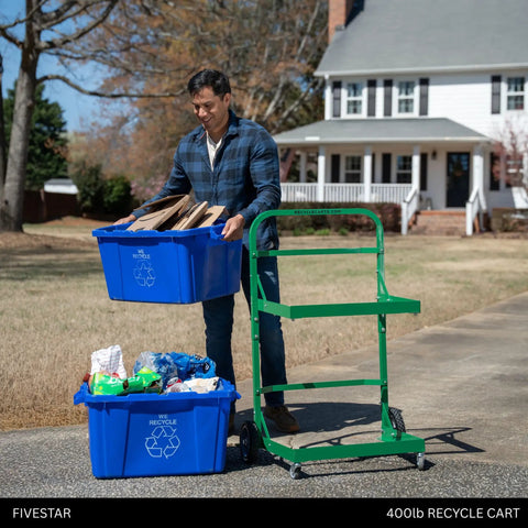 Man using Tough As Nails Heavy Duty Recycle Bin Cart with Aluminum Frame, loading cardboard into blue recycling bins.
