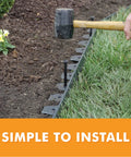 Person installing Tall Wall No Dig Landscape Edging Kit for DIY gardens using a mallet on grass and soil with anchoring spikes