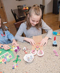 Children using premium natural wood craft sticks for DIY arts and crafts projects at home, surrounded by colorful materials.