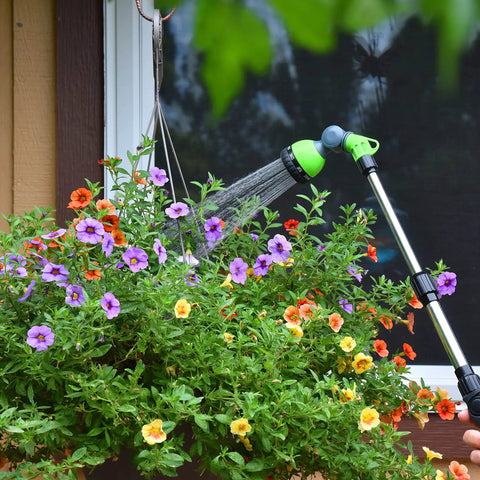 Telescoping Watering Wand With 18 To 24 Inch Reach, Zinc Alloy Handle, used for watering hanging planters in garden scene.