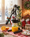 Cast Iron Manual Citrus Juicer Heavy Duty Orange Press with orange juice in jar and festive decor on kitchen table.