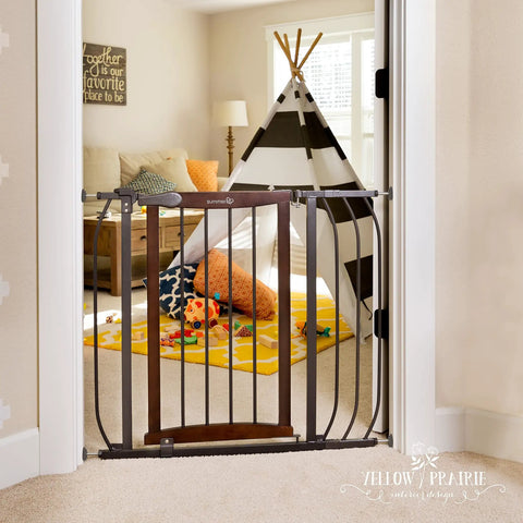 Walk Through Baby And Pet Gate With Walnut Wood And Charcoal Metal Accents displayed in doorway with kids' play area in background