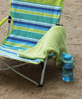 Utopia Breeze Lightweight Beach Chair With Cup Holder And Carry Bag For Easy Outdoor Relaxation on sand with towel and bottle