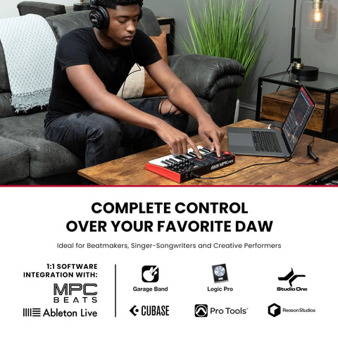 Man using MPK Mini MK3 25 Key USB MIDI Keyboard Controller with 8 backlit drum pads and knobs connected to laptop for music production