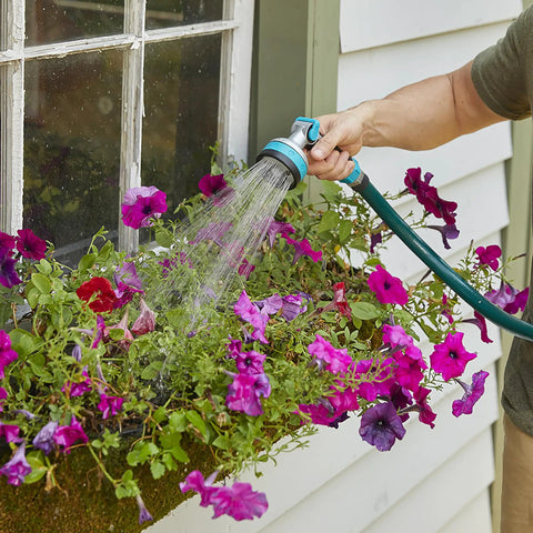 Heavy Duty Thumb Control Garden Hose Nozzle With Eight Pre Set Spray Patterns watering flowers, ergonomic non slip handle in use
