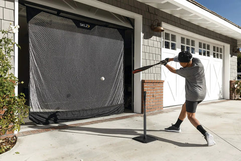 Player using 7 Foot Wide Baseball Softball And Golf Hanging Practice Net For Home Hitting Pitching And Driving Practice, Rolls Up Easily for Garage Storage.