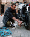 Mechanic working on motorcycle with 2-Piece Silicone Tool Tray Set, showing tools organized for sockets, nuts, bolts, and bits.