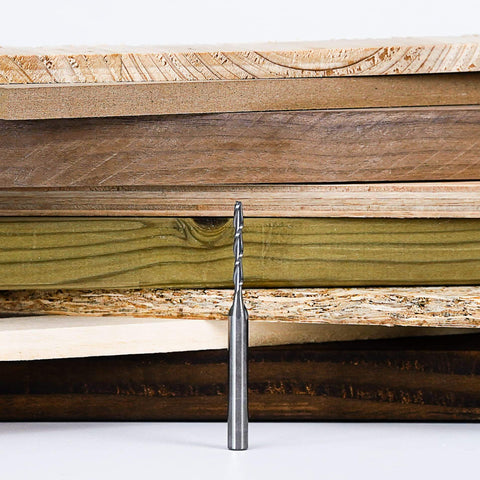 Five Piece Spiral Upcut Router Bit Set With One Eighth Inch Cutting Diameter And One Quarter Inch Shank in front of wood planks