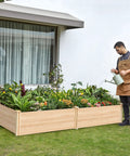 Person watering plants in a Wood Raised Garden Bed 8x4 Ft with 15 Inch Depth Planter Box for Veggies, Herbs, and Blooms