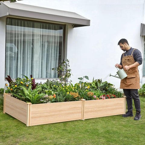 Person watering plants in a Wood Raised Garden Bed 8x4 Ft with 15 Inch Depth Planter Box for Veggies, Herbs, and Blooms