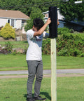 Person using Beefy Post Driver And Rammer For Fence Installations Heavy Duty 30 Lb Tool 24 Inch Tall With 13 Inch Wide Grip on wood post