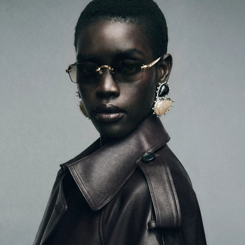 Model wearing ASAP Rocky RB3928 Slim Rimless Metal Rectangular Sunglasses in Gold and Dark Green 54mm Frames with a leather coat