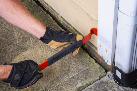 15 Inch Flat Pry Bar With Grip For Demolition And Prying Nails Precision Ground Edges Beveled Nail Slots High Visibility Rust Resistant Finish Durable Heavy Duty Pry Tool For Pros And DIYers being used to pry siding