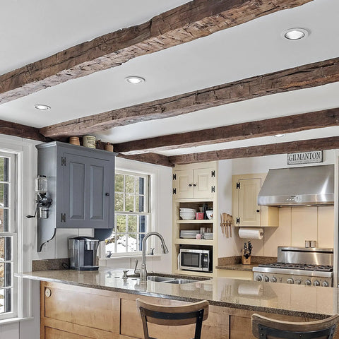 Big Time Brightness Rotatable Led Retrofit Downlight Gimbal in a kitchen ceiling with exposed beams and modern decor.