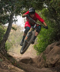 Mountain biker in red gear using Trail Ready Tire Insert Set With Two Inserts, Two Presta Valves And Rim Stickers on rocky trail.