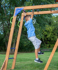 Child using monkey bars on Beachfront Cedar Wood Swing Set With Wave Slide Elevated Deck Canopy Monkey Bars Rock Wall Ladder