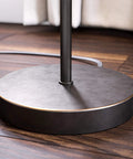 Base of Netherlands Floor Lamp In Oil Rubbed Bronze Finish on wooden floor, minimalist Scandinavian-inspired design
