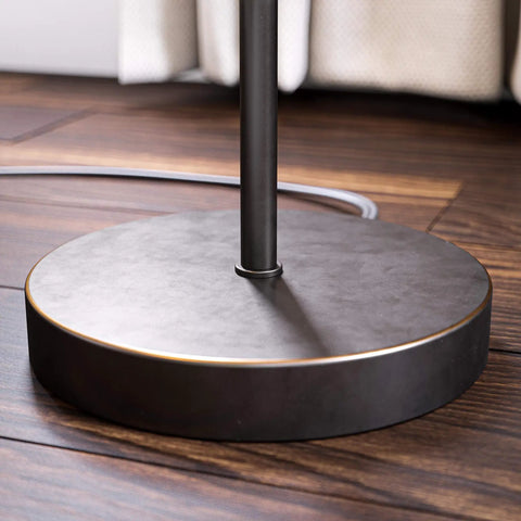 Base of Netherlands Floor Lamp In Oil Rubbed Bronze Finish on wooden floor, minimalist Scandinavian-inspired design