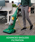 Heavy Duty Bagless Upright Vacuum Chomping Debris On Carpets Hardwood Floors And Furniture With Beastly Suction Plus Onboard Tools And Commercial Filtering For Daily Grind Cleaning standing in office with cord.