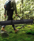 Person carrying Extra Large Hammock Storage Bag For Double Hammock And 12 Foot Steel Stand With Zipper Closure in a forest