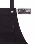 Close-up of Deluxe Waxed Canvas Tool Apron material with focus on front pocket and durable metal ring accent.