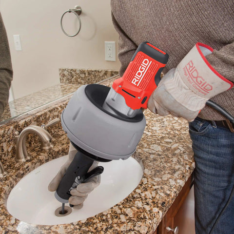 K-45AF Air Powered Drain Cleaner 230V Drum Auger for Swage Lines and Sewer Pipes in use near bathroom sink.