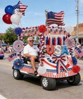 Man driving golf cart decorated with All In One 4th Of July Golf Cart Decor Kit For Parades And Independence Day Patriotic Banner Tassel Garlands Fringe Curtains Star Garlands Paper Pompoms And Flag Balloons To Deck Out Your Ride in parade